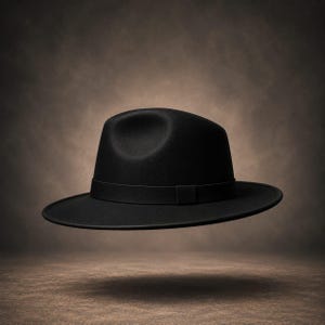 Può includere: Un cappello fedora nero a tinta unita caratterizzato da una corona strutturata con un'indentazione centrale e un nastro in gros-grain nero abbinato che circonda la base della corona, rifinito con una tesa piatta e larga che si estende orizzontalmente.