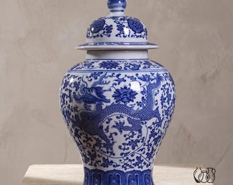 May include: A blue and white ceramic ginger jar featuring a detailed dragon motif and floral patterns. The vessel has a rounded body, a tapered base, and a removable lid with a pointed finial. The surface is decorated with intricate blue designs.