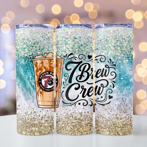 Puede incluir: Un vaso cilíndrico con un patrón de olas en color verde azulado y blanco, con detalles de purpurina dorada en la parte superior e inferior. Incluye una ilustración de un café helado con el logo 7 Brew y el texto cursivo 7 Brew Crew.