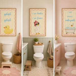 May include: Three vertical wall art prints in wooden frames featuring yellow striped backgrounds with pink scalloped borders. The prints display cartoon ducks and text reading splash splash, i see london i see france, and i see coco's underpants.