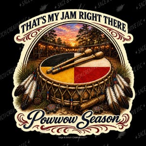 May include: A circular drum with a four-quadrant top featuring black, yellow, red, and white colors. Two wooden drumsticks rest on top. The drum is decorated with feathers and pine cones. Text reads: THAT'S MY JAM RIGHT THERE and Powwow Season.