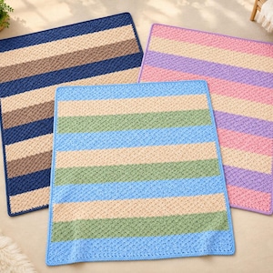 May include: Three square crochet blankets featuring horizontal stripes. One blanket has navy blue, brown, and beige stripes. Another has pink, purple, and beige stripes. The third has light blue, green, and beige stripes.