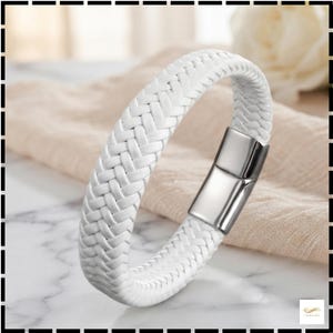 May include: A white braided bracelet featuring a smooth, polished silver-tone metal clasp. The band is constructed from multiple interwoven strands, creating a consistent textured pattern throughout the entire length of the circular accessory.