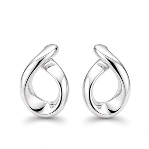 May include: A pair of polished silver earrings featuring a continuous, twisted teardrop shape. The metal surface is smooth and reflective, creating a fluid, open-loop design that curves inward at the top and widens towards the base of each earring.