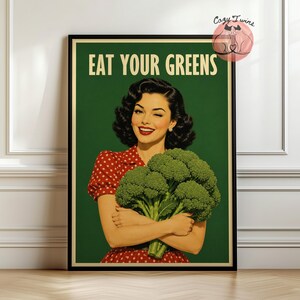 Könnte beinhalten: Ein gerahmtes Poster mit einer Illustration im Retro-Stil einer Person mit dunklem, gewelltem Haar in einem rot gepunkteten Oberteil, die einen großen Brokkoli hält. Der Text EAT YOUR GREENS ist in Creme auf dunkelgrünem Grund gedruckt.