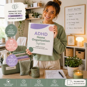 Puede incluir: Una carpeta blanca titulada ADHD Home Organization System con formas abstractas moradas y rosas en la portada. La carpeta se muestra junto a un contenedor de almacenamiento verde etiquetado como Cleaning, una taza verde y un planificador diario.