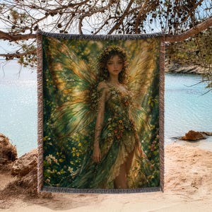 May include: A woven throw blanket featuring a detailed illustration of a fairy with large, translucent wings, wearing a dress adorned with green leaves and small flowers, surrounded by a forest setting with golden light and soft green foliage.