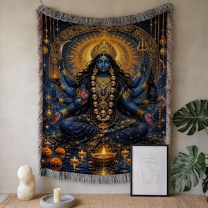 May include: A woven tapestry featuring a multi-armed blue deity with a golden crown and skull necklace, seated in a meditative pose. The scene includes a glowing halo, a trident, a sword, and floating oil lamps on dark water with fringe edges.