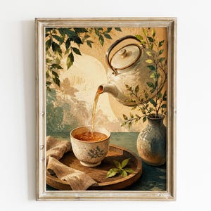 Puede incluir: Una impresión de arte mural enmarcada que muestra una tetera de color claro vertiendo té ámbar en una taza de cerámica a juego. La escena incluye un pequeño jarrón con ramas verdes, una bandeja de madera y una tela beige sobre un fondo cálido.