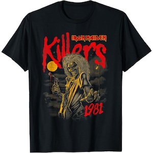 May include: A black short-sleeve t-shirt featuring a graphic print of the Iron Maiden Killers album artwork. The design displays a character with wild hair holding a bloody axe, with the text Killers and 1981 in red, set against a dark background.