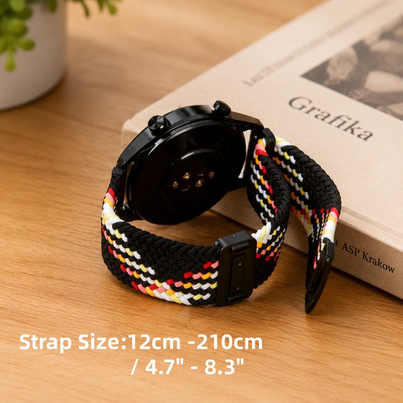 May include: A black smartwatch with a braided elastic strap featuring a multi-colored pattern of red, yellow, and white threads. The watch case is black with two side buttons. The strap size is listed as 12cm - 210cm / 4.7" - 8.3".