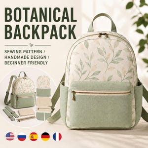 May include: A backpack featuring a cream-colored fabric with a green leaf pattern, accented by solid sage green panels on the front pocket and sides. It includes a top handle, shoulder straps, and a zippered front pocket with metallic hardware.