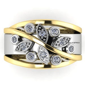 May include: A two-tone ring featuring a wide silver band overlaid with curved yellow gold bands. The center is decorated with a leaf-inspired motif containing multiple round brilliant-cut diamonds set in silver, with the text JDLUXEJEWELS visible.