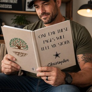 May include: A hardcover book with a beige cover featuring a green tree illustration with roots on the left page and the black text "ONE DAY THESE PAGES WILL TELL MY STORY" above a star and the name "Christopher" on the right page.