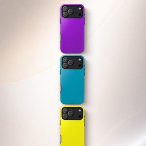 May include: Three smartphone cases arranged vertically in a column. The top case is purple, the middle case is teal, and the bottom case is yellow. Each case features a black rectangular camera module housing three circular lenses and a flash.
