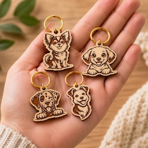 Pode incluir: Quatro pequenos porta-chaves de madeira com ilustra&ccedil;&otilde;es gravadas a laser de diferentes ra&ccedil;as de c&atilde;es. Cada porta-chaves tem um anel de metal dourado fixado no topo. Os desenhos incluem um c&atilde;o de pelo comprido, um cachorro, um c&atilde;o com manchas e um pequeno terrier.
