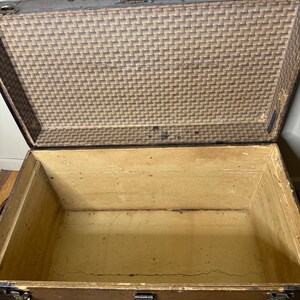Open interior of the large antique trunk showing a clean, original interior storage space, ready for blankets or linens.