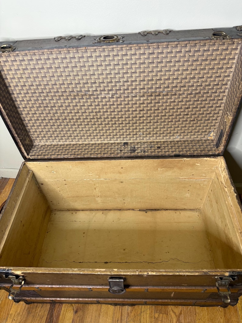 Open interior of the large antique trunk showing a clean, original interior storage space, ready for blankets or linens.