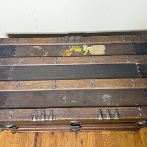 Top-down view of the flat lid highlighting the original wood banding, metal rivets, and weathered canvas surface