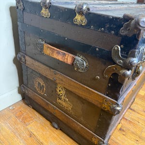 Close-up of the original solid wood slats and metal rivets on the lid of the 1890s canvas-covered trunk
