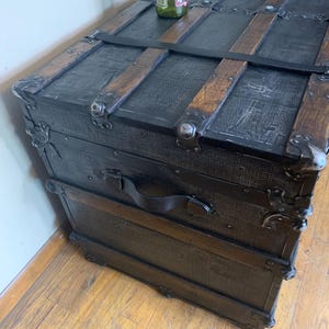 Side profile of a huge 19th century travel chest refinished in black