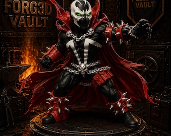 May include: A Spawn action figure standing on a circular base labeled FORG3D VAULT. The figure features a black suit with white markings, a flowing red cape, silver spiked gauntlets and greaves, and a silver chain with a skull emblem at the waist.