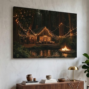 Peut inclure: Une impression murale rectangulaire représentant une cabane en bois nichée dans une forêt sombre la nuit. La cabane est éclairée par des guirlandes lumineuses chaudes suspendues entre de grands arbres. Un feu de camp brûle près d'un étang.
