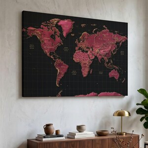 May include: A rectangular wall art piece featuring a world map with deep magenta landmasses against a black grid background. The continents are rendered with a textured, metallic gold outline and detailing, displaying country names in small gold text.