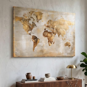 Peut inclure: Une œuvre d'art murale rectangulaire représentant une carte du monde en feuille d'or métallique sur un fond texturé gris clair et beige. Les continents présentent une finition vieillie et superposée, créant un effet visuel contrasté.
