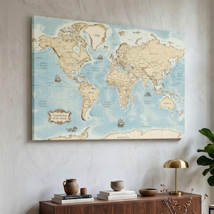May include: A rectangular wall art print featuring a vintage-style world map with beige landmasses and light blue oceans. The map displays country names, grid lines, and decorative illustrations of sailing ships and sea creatures with the text Countries of the World.