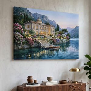 May include: A rectangular wall art print depicting a grand villa with a domed roof situated on a lakeshore. The scene features stone stairs leading to the water, a small wooden boat docked nearby, lush pink and purple flowering bushes, and mountains.