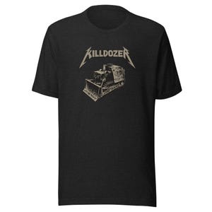 May include: A charcoal gray short-sleeve t-shirt featuring a graphic print on the chest. The design includes the word KILLDOZER in a stylized font above a detailed illustration of a bulldozer in shades of light gray and white.