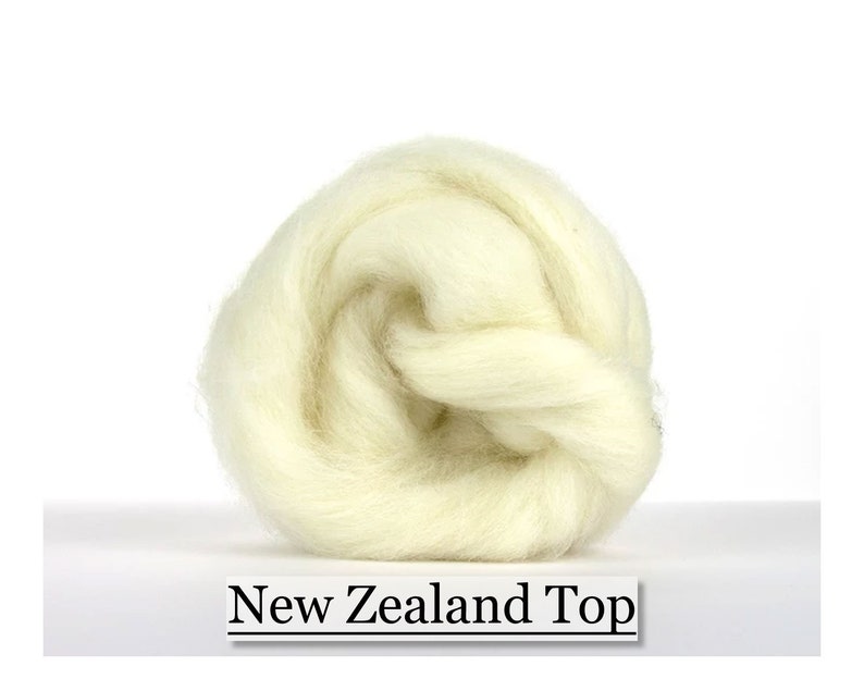 May include: A compact, cream-coloured ball of New Zealand Top wool, suitable for various craft applications. The wool appears soft and fluffy, presented against a plain white backdrop. The words "New Zealand Top" are printed on a white label.