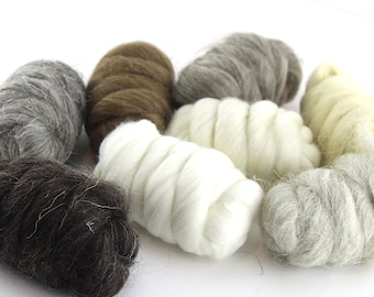 May include: Close-up of several bundles of wool roving in various natural colors, including white, gray, brown, and cream. The wool is soft and fluffy, ideal for fiber art projects like felting and spinning.