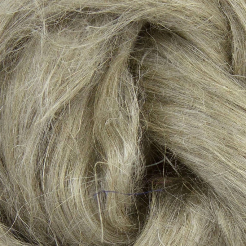Puede incluir: Primer plano de fibra de lino cruda y natural en tonos beige y gris. Las fibras son largas, fluidas y texturizadas, creando una apariencia suave y org&aacute;nica. Esta imagen muestra la materia prima utilizada en la producci&oacute;n textil.
