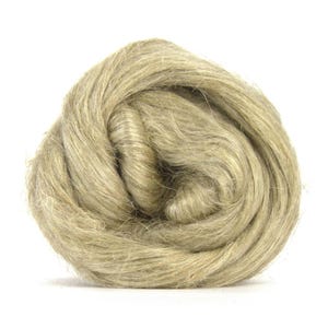 Puede incluir: Primer plano de un ovillo de fibra de lino de color natural, en tonos beige y marr&oacute;n claro. Las fibras finas y texturizadas crean un aspecto suave y org&aacute;nico. Esta materia prima se utiliza probablemente para manualidades textiles.