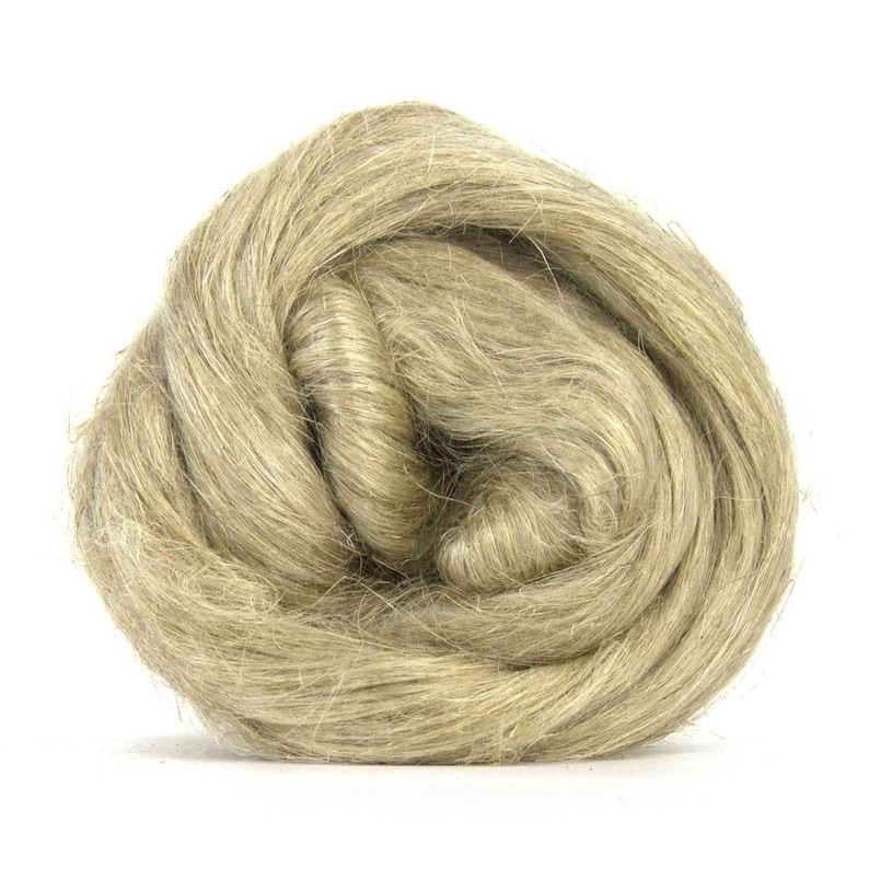 Puede incluir: Primer plano de un ovillo de fibra de lino de color natural, en tonos beige y marr&oacute;n claro. Las fibras finas y texturizadas crean un aspecto suave y org&aacute;nico. Esta materia prima se utiliza probablemente para manualidades textiles.