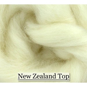 May include: Close-up of a pile of off-white New Zealand Top wool fibres. The fibres are soft and fluffy, with a slightly textured appearance. The text "New Zealand Top" is displayed at the bottom of the image.