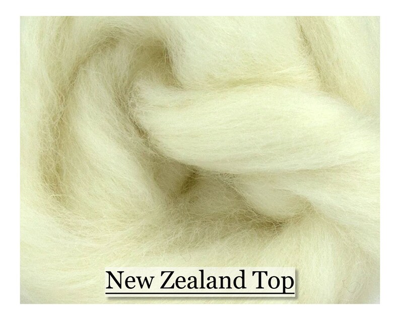 May include: Close-up of a pile of off-white New Zealand Top wool fibres. The fibres are soft and fluffy, with a slightly textured appearance. The text "New Zealand Top" is displayed at the bottom of the image.