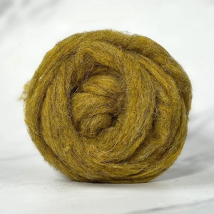 May include: A round ball of olive green wool roving with a soft, fuzzy texture. The fibers are densely wound in a circular pattern, creating a thick, continuous strand of unspun material with visible variations in the deep green color.