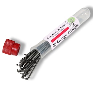 May include: A clear plastic tube containing a bundle of silver-colored felting needles. The tube has a red cap and a label that reads "Cupid Falls Farm Felting Needles 40 Gauge Triangle."