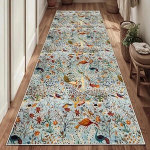 May include: A long rectangular runner rug featuring a light blue background with a dense, colorful pattern of stylized birds, including peacocks, and intricate floral and tree motifs in shades of orange, red, green, and dark blue.