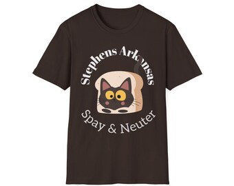 Op de afbeelding: Een donkerbruin T-shirt met korte mouwen en een afbeelding van een zwarte kat die uit een snee brood kijkt. De tekst 'Stephens Arkansas' staat in een boog boven de kat en 'Spay & Neuter' staat in een gebogen lijn onder de illustratie.