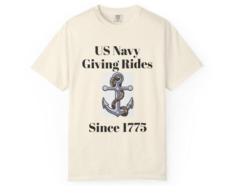 Op de afbeelding: Een crèmekleurig T-shirt met korte mouwen met de zwarte tekst US Navy Giving Rides en de tekst Since 1775. Tussen de tekstregels staat een grafische illustratie van een grijs metalen anker omwikkeld met een bruin touw op een witte achtergrond.