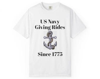 Op de afbeelding: Een wit t-shirt met korte mouwen en de zwarte tekst US Navy Giving Rides Since 1775. Gecentreerd tussen de tekst staat een grafische illustratie van een grijs metalen anker dat is omwikkeld met een bruin touw op een witte achtergrond.