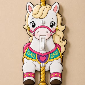 May include: A white carousel horse light switch cover featuring a blonde mane, a pink bridle, and a colorful saddle with a heart design. The switch is positioned in the center of the horse's face, and a yellow pole extends from the bottom.