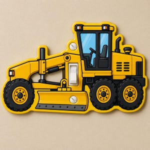 May include: A yellow motor grader light switch cover featuring a detailed construction vehicle design with black tires, a central white toggle switch, and two visible silver screws integrated into the body of the machine illustration.