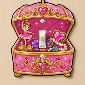 May include: A pink and gold light switch cover shaped like a jewelry box. The design features a ballerina on a circular base, a string of white pearls, and purple and blue gemstones. A central white toggle switch is integrated into the center.