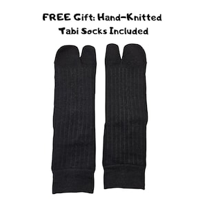 Puede incluir: Un par de calcetines tabi negros tejidos a mano con un dise&ntilde;o de punta dividida y textura acanalada. El texto sobre los calcetines dice: FREE Gift: Hand-Knitted Tabi Socks Included. Estos calcetines tienen una separaci&oacute;n clara entre el dedo gordo.