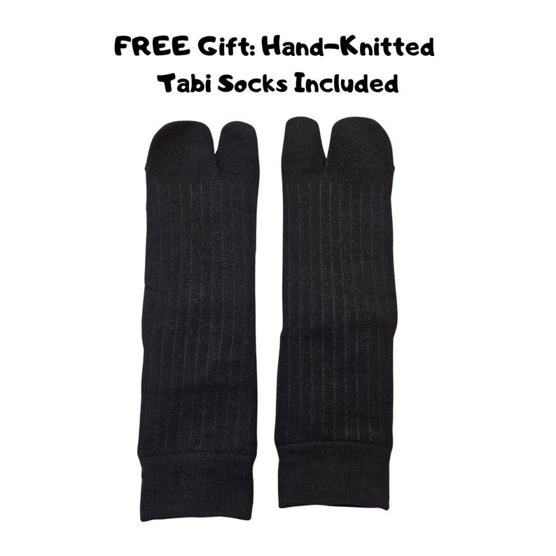 Puede incluir: Un par de calcetines tabi negros tejidos a mano con un dise&ntilde;o de punta dividida y textura acanalada. El texto sobre los calcetines dice: FREE Gift: Hand-Knitted Tabi Socks Included. Estos calcetines tienen una separaci&oacute;n clara entre el dedo gordo.